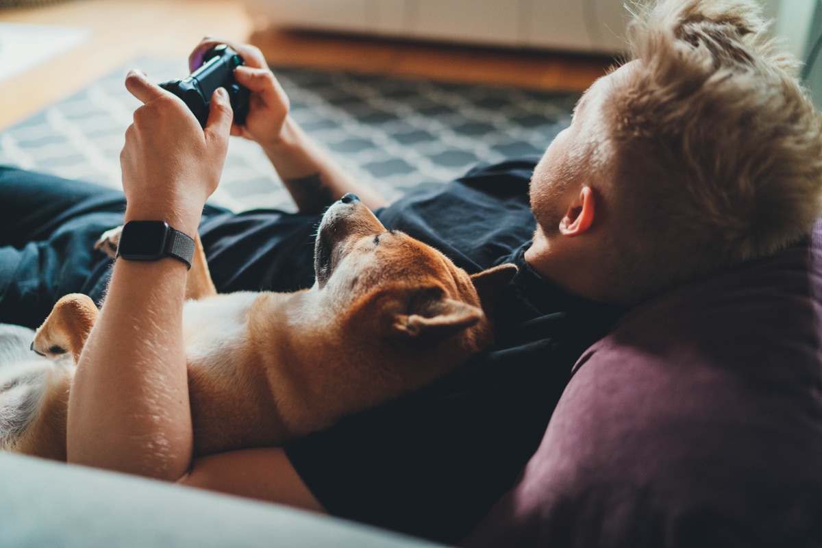 Man plays PlayStation with his dog